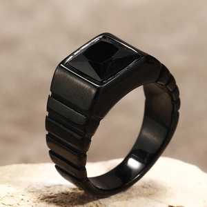Gros plan d'une bague en acier titane noir avec une pierre précieuse carrée noire
