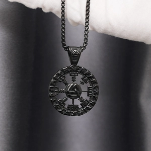 Macro detail of a black Viking Valknut pendant with Nordic runes held in white gloves