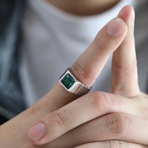 Détail macro d'une bague pour homme en acier titane avec pierre verte et anneau texturé