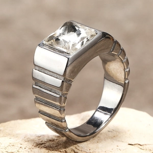 Gros plan d'une bague pour homme en acier titane avec un grand diamant carré chic