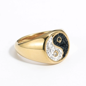 Macro shot of gold signet ring featuring black and white Yin Yang crystal inlay detail