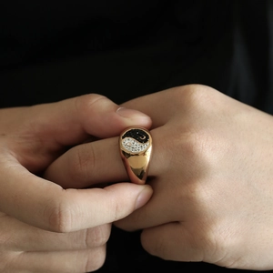 Close-up of golden signet ring featuring Yin Yang design with black and white rhinestones