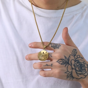 Gold stainless steel floral relief pendant necklace with box chain on model