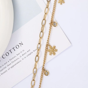 Detail van de gouden dubbellaagse sneeuwvlok hanger ketting met zirkonia details