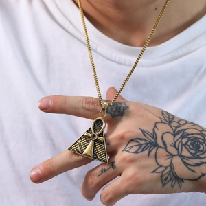 Detail of gold Eye of Horus pyramid and Ankh cross pendant on a wheat chain