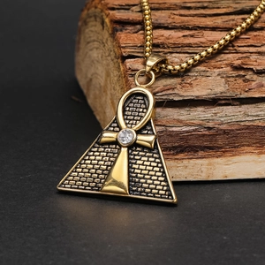 Macro view of gold Egyptian Eye of Horus pyramid pendant with Ankh cross and zircon