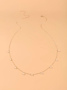 Détail d'une chaîne de taille dorée avec perles d'imitation et fermoir mousqueton réglable