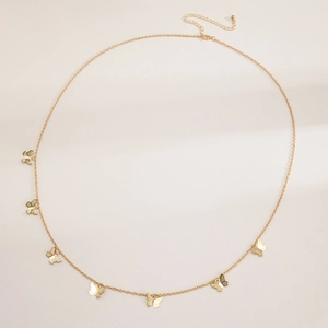 Detail of gold butterfly tassel waist chain with adjustable lobster clasp and metal charms