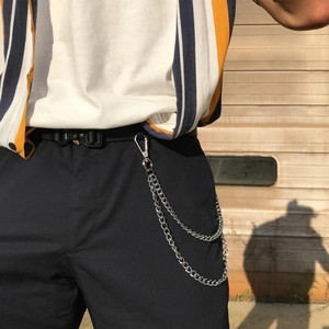 Détail d'une double chaîne de pantalon en métal argenté avec fermoir mousqueton sur jean