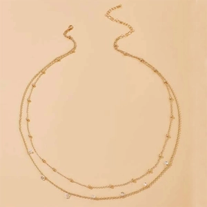 Detail of double-layer waist chain featuring gold beads and sparkling zircon pendants