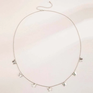 Detail of silver chain belt featuring multicolored butterfly pendants on silk fabric