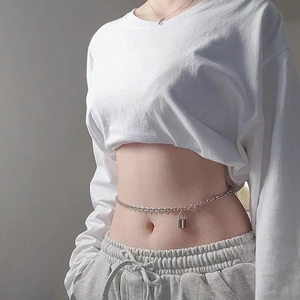 Detailed view of punk style silver chain belt with lock pendant on casual pants