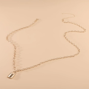 Detail shot of a golden punk style padlock pendant with long adjustable O-ring chain