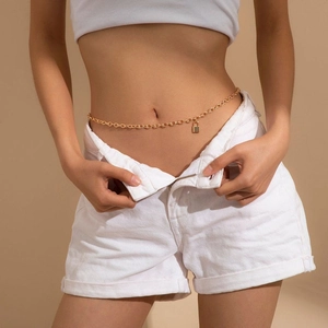 Close-up of a gold-toned chain waist belt with a lock pendant on a female model