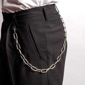Détail d'une chaîne de pantalon punk argentée avec mousquetons sur un pantalon