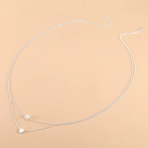 Détail de la chaîne de taille argentée à double rangée avec pendentifs cœur et perle