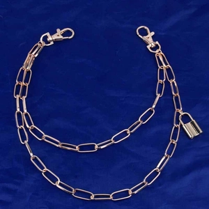 Detail of golden punk multi-layer trouser chain with lobster clasp and padlock charm