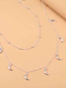 Détail de la chaîne à deux rangs argentée avec pendentifs demi-lune et petites perles