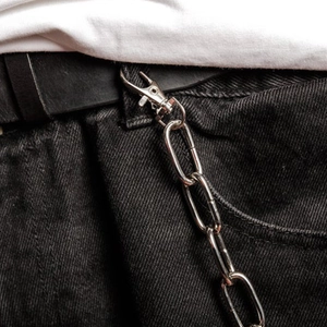 Gros plan d'une chaîne de pantalon punk hip-hop argentée sur un jean noir usé