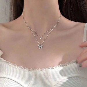 Détail d'un collier papillon double couche avec cristaux étincelants sur un mannequin
