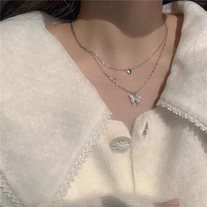 Gros plan d'un collier papillon argenté à deux rangs orné de cristaux étincelants