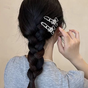 Barrettes à cheveux ours évidé en argent avec strass sur des cheveux tressés foncés