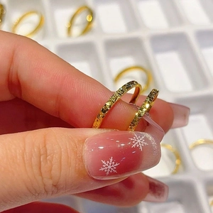 Close-up of golden slim rings with star-shine hammered texture on hands