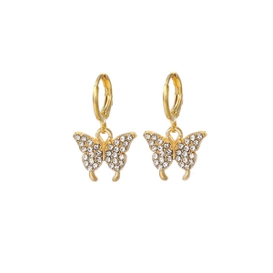 Détail de boucles d'oreilles papillon à double couche avec cristaux blancs et plaqué or