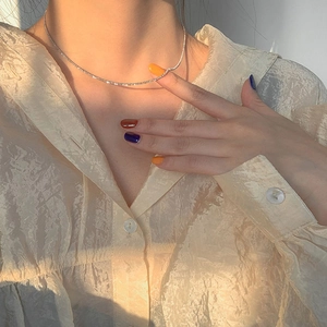 Sparkling silver starlight snake chain necklace worn on collarbone with warm sunlight
