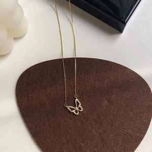 Detailed view of a gold-plated bow necklace with sparkling zircon pavé on a brown felt pad