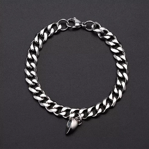 Close-up of silver Cuban chain bracelet with magnetic half-heart pendant and lobster clasp