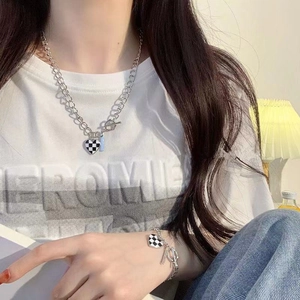 Gros plan du pendentif cœur en damier sur une chaîne argentée épaisse avec fermoir OT