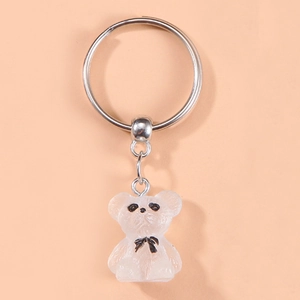 Cute teddy bear keychain with bow tie on soft orange background for bags and car keys