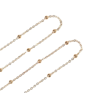 Macro shot of rose gold bead chain with smooth metallic spheres and elegant link texture