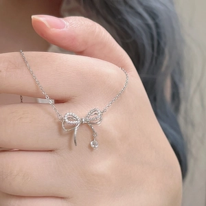 Détail d'un collier nœud en argent avec pavé de zircons et pendentif diamant scintillant
