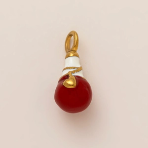 Macro detail of red and white enamel lucky bag pendant with gold relief patterns