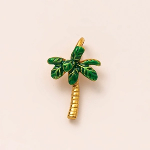 Vue macro d'un pendentif palmier plaqué or 18K avec détails tropicaux en émail vert