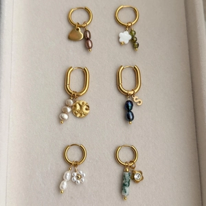 Dettaglio di orecchini placcati oro 18 carati con perle e ciondoli in una custodia