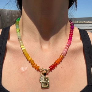 Close-up of a colorful beaded necklace featuring a gold letter A pendant for women