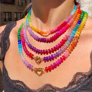 Colorful multi-layer rainbow bead necklace with golden heart clasp in natural sunlight