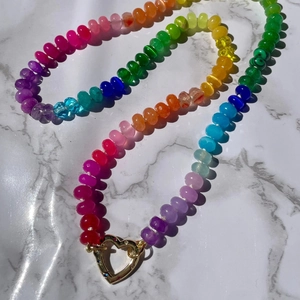 Detailed macro view of vibrant rainbow beaded necklace with gold heart-shaped clasp