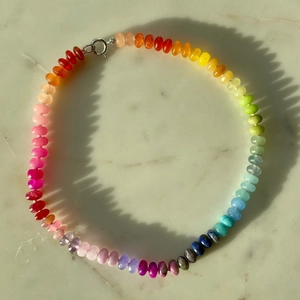 Detailed overhead view of colorful rainbow beaded necklace with a silver spring clasp