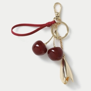 Close-up of elegant cherry keychain with resin fruits, gold leaves and red leather strap
