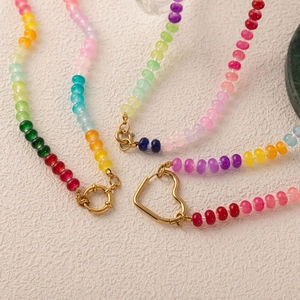 Close-up of rainbow gradient beads with gold-tone heart and round lobster clasps