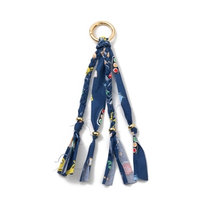 Detail of dark blue woven keychain with traffic prints and gold metal bead accents