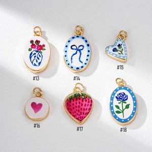 Detailansicht vergoldeter Emaille-Anhänger mit floralen Motiven und Schleifen-Design