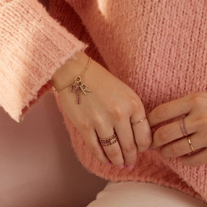 Détail d'un ensemble de bijoux en or 18 carats avec pendentifs cœur et bagues roses