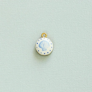 Detail van ronde wit geëmailleerde hanger met blauw schelpmotief en gouden lus