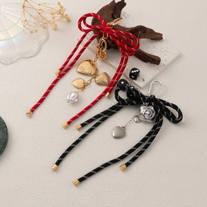 Handmade woven bow keychains with 18K gold-plated heart pendants and pearl accents