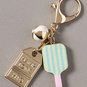 Detailed macro view of a gold lobster clasp keychain with a striped paddle and metal tag